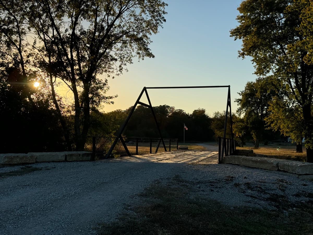 Farm gate silhouette at sunset