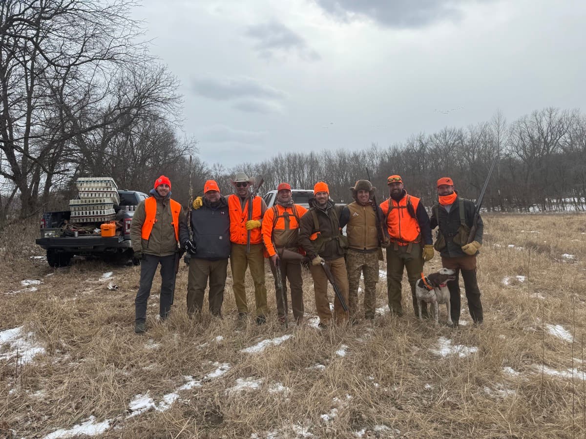 Hunting crew in blaze orange with a bird dog