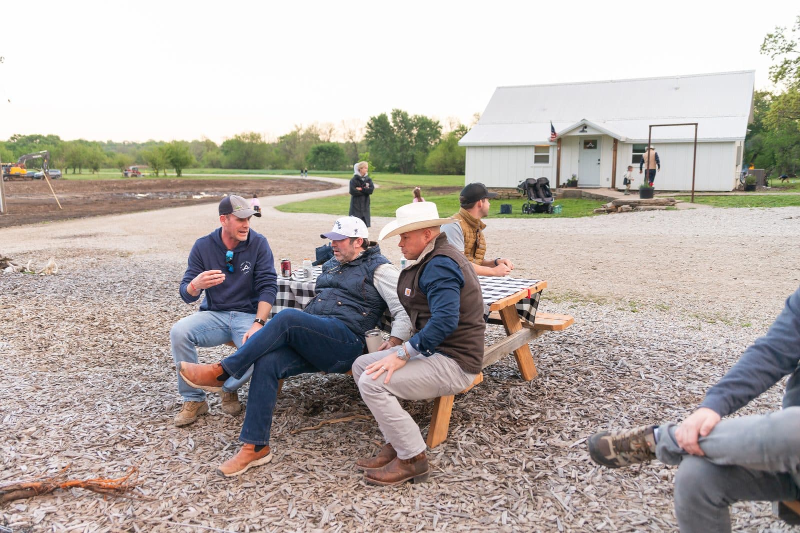 Guys hanging out at the bench, barn in the background