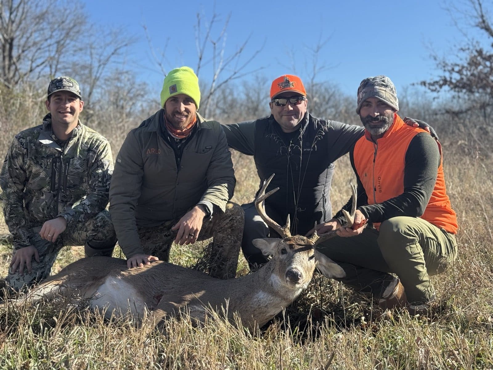 Hunting crew with a whitetail buck
