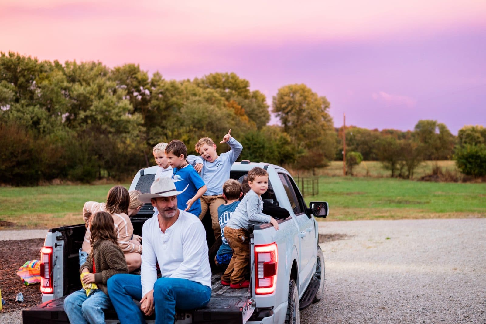 Dad and kids piled in the truck bed at sunset